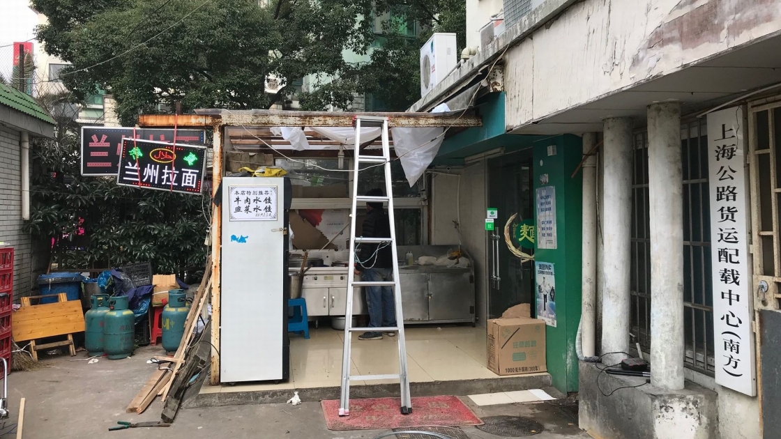 電気の配線か何かを修理中の、蘭州牛肉麺のお店の入り口